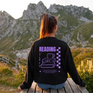 a woman sitting on a bench reading a book
