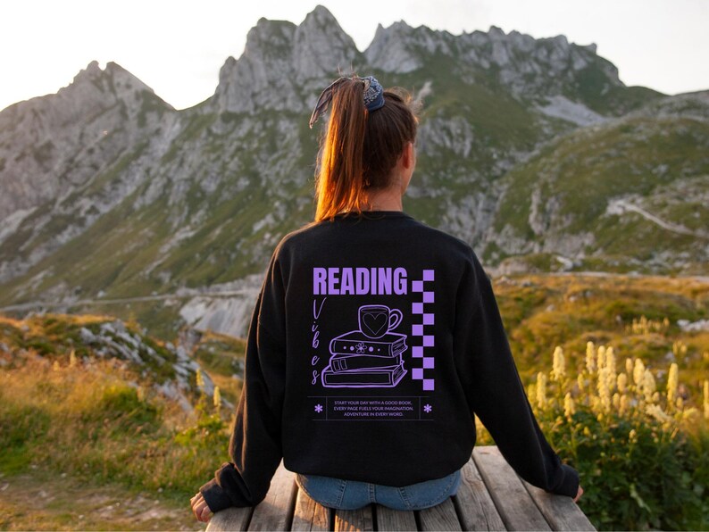 a woman sitting on a bench reading a book