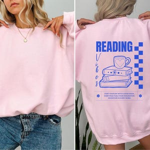 a woman wearing a pink sweatshirt with reading on it