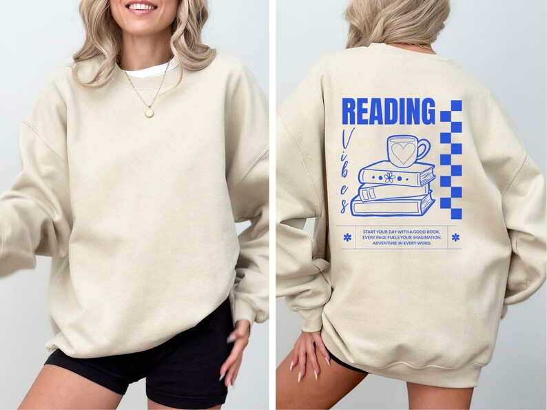 a woman wearing a sweatshirt that reads reading with a stack of books on it