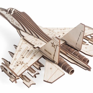 Op de afbeelding: Een geassembleerd houten model van een Russisch Su-35-gevechtsvliegtuig. Het model heeft gedetailleerde markeringen, waaronder de Russische vlag en de tekst "РОССИЯ".
