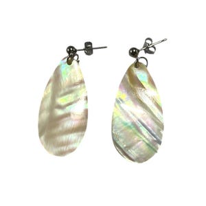 May include: A pair of iridescent teardrop earrings. The earrings have a pearlescent, opalescent finish with a silver-tone post. The earrings are set against a white background.