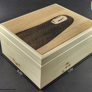 May include: A wooden box with a No Face character from the movie Spirited Away on the lid. The box is 7.75 inches wide, 6.25 inches deep, and 3.75 inches tall.