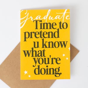 May include: A graduation greeting card with a bright yellow background and the words "Graduate Time to pretend u know what you're doing" in black and white. The card is on a brown envelope with white stars.