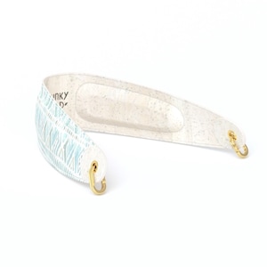 May include: A white camera strap with a blue and white patterned design and gold metal hooks.