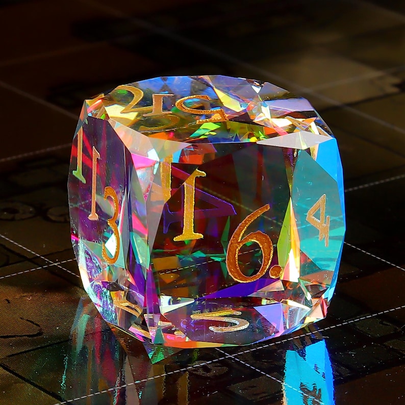 May include: A multi-faceted iridescent crystal dice with gold numbers 1, 2, 3, 4, 5, and 6.