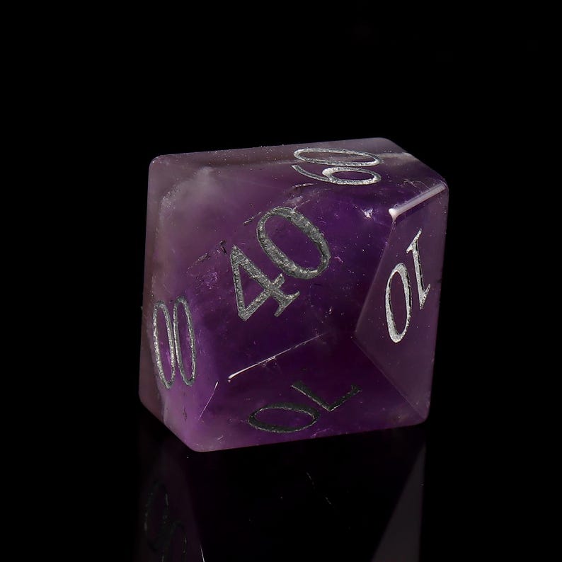 May include: A purple amethyst gemstone dice with silver numbers 10, 40, 60, and 00.