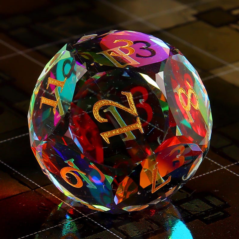 May include: A multi-faceted iridescent crystal dice with gold numbers 1 through 6. The dice is a deep red color with rainbow reflections.