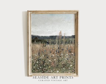 May include: A vintage painting of a field of wildflowers in shades of blue, white, and brown. The painting is framed in a light wood frame. The background shows a distant forest and a cloudy sky.