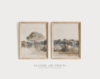 May include: Two framed watercolor paintings of landscapes with trees and a house in the distance. The paintings are in a light brown frame and have a vintage aesthetic.
