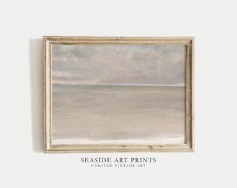 May include: A framed painting of a seascape with a light blue horizon and a cloudy sky in shades of gray and pink. The frame is a light wood color.