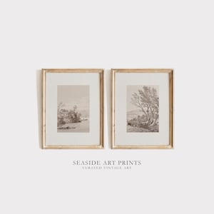 Peut inclure: Deux impressions de paysages en sépia encadrées avec un cadre en bois. Les impressions représentent une scène de bord de mer avec des arbres et un bâtiment au loin. Le texte "SEASIDE ART PRINTS CURATED VINTAGE ART" est situé sous les impressions.
