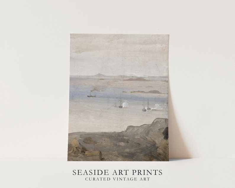 May include: A vintage seascape painting with a muted color palette. The painting depicts a body of water with several ships in the distance. The water is a light blue color and the sky is a light gray color. The foreground of the painting is a rocky cliff with a brown and gray color palette. The painting is framed with a white mat and a white frame. The text below the painting reads 'SEASIDE ART PRINTS CURATED VINTAGE ART'.