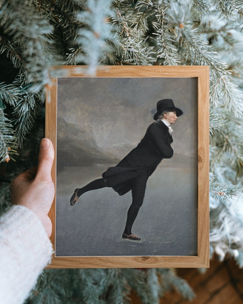 May include: A framed painting of a man in a black coat and top hat ice skating on a frozen lake. The painting is set against a gray and white background.