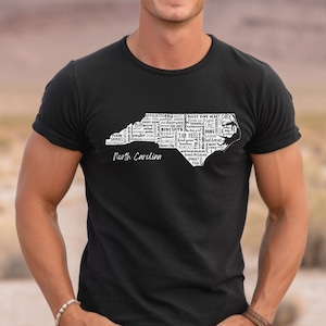 Pu&ograve; includere: Una maglietta nera con un contorno bianco dello stato della Carolina del Nord. Il contorno &egrave; riempito con parole relative allo stato, come "BBQ", "Biscuits", "Tar Heel", "Duke" e "UNC". Le parole "Carolina del Nord" sono stampate sotto il contorno.