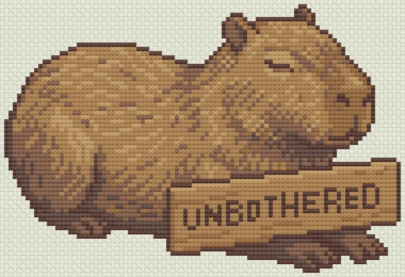 May include: A pixelated illustration of a capybara in shades of brown, lying down with its eyes closed. The capybara holds a sign that reads "UNBOTHERED" in block letters. The background is a light beige.