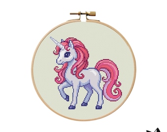 May include: A cross-stitch embroidery of a unicorn in a wooden hoop. The unicorn is white with a pink mane and tail, and a silver horn. The background is a light green fabric. The text "SWEET STITCHY STUDIO" is at the bottom.