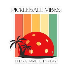 Puede incluir: Una pegatina con un diseño retro que presenta una pelota de pickleball roja, palmeras y un fondo a rayas de colores. Se muestra el texto "PICKLEBALL VIBES" y "LIFE'S A GAME. LET'S PLAY."