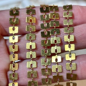 May include: Gold chain made of small square links with a hole in the center of each link.