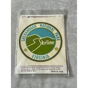 May include: A vintage Shenandoah National Park Skyline Virginia windshield decal in a clear plastic sleeve. The circular design features a green and blue landscape with text and star accents. Made in the U.S.A.