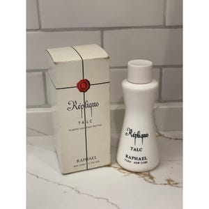 May include: A white plastic squeeze bottle of Réplique talc with a matching box. The box and bottle feature the Réplique logo and the text "TALC". The box also includes the text "RAPHAEL" and "NET CONT 2 3/4 oz."