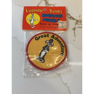 May include: A Looney Tunes character patch featuring Sylvester the Cat in a yellow circle with a red border. The patch reads "Great Adventure" and is packaged with a Looney Tunes header card.