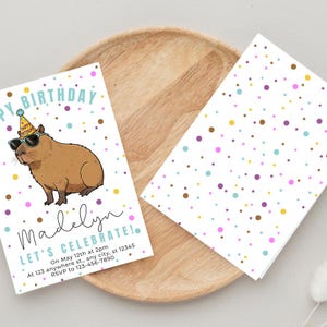 May include: Birthday invitation featuring a cartoon capybara wearing sunglasses and a party hat. The invitation includes the text "Happy Birthday Madelyn! Let's Celebrate!" with event details and RSVP information. The background is white with colorful polka dots.