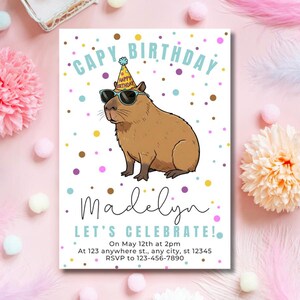 May include: A birthday invitation featuring a cartoon capybara wearing sunglasses and a party hat. The text reads "CAPY BIRTHDAY" and "LET'S CELEBRATE!" with the name "Madelyn" and event details. The design includes colorful polka dots.