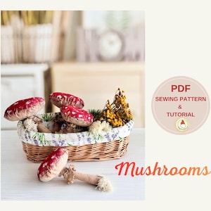 May include: A wicker basket filled with decorative mushrooms. The mushrooms have red caps with white spots and beige stems. The basket is lined with a floral fabric and contains dried flowers. The word "Mushrooms" is written in orange script.