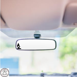 May include: A rearview mirror with a black microscope sticker on the glass.