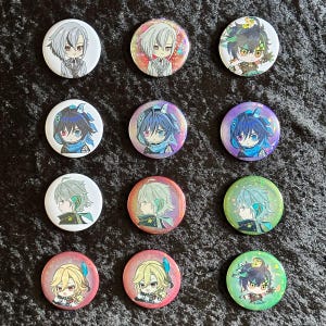 May include: A collection of twelve round, colorful anime-style button pins. Each pin features a different character design with varying hair colors, outfits, and expressions. The pins are arranged on a dark, textured surface.