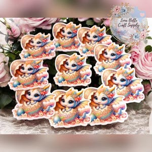 May include: Ten colorful resin cabochons featuring a baby dragon hatching from an egg. The dragon has blue wings, a pink flower crown, and a yellow, orange, and pink egg. The cabochons are perfect for crafting projects.