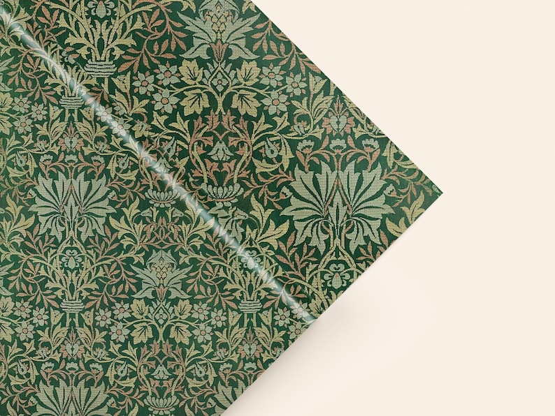 a close-up view of a decorative green and gold patterned fabric or paper with a repeating floral and leaf design.