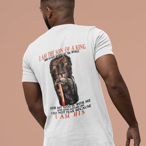Pode incluir: Camiseta branca com um gr&aacute;fico de um le&atilde;o preto e o texto "Eu sou o filho de um rei que n&atilde;o &eacute; movido pelo mundo. Porque o meu Deus est&aacute; comigo e vai &agrave; minha frente. N&atilde;o temo porque sou seu."
