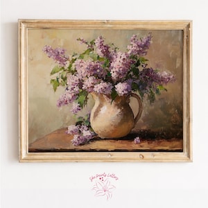 Peut inclure: Peinture à l'huile d'un bouquet de lilas violets dans une cruche crème. La peinture est dans un cadre en bois doré. L'œuvre d'art est sur une surface en bois avec un fond neutre. La signature de l'artiste est en bas à droite.