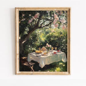 May include: An oil painting shows a garden picnic. A white tablecloth covers a table set with food and drinks. A tree with pink blossoms shades the table. The painting is in a gold-coloured frame.