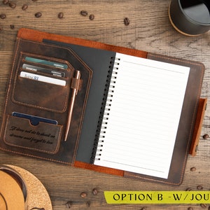 May include: Open leather journal with a spiral-bound notebook and card slots. A rose gold pen rests in a loop. The journal has the quote "It does not do to dwell on dreams and forget to live." A black mug of coffee sits nearby.