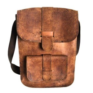 Peut inclure: Sac messager en cuir marron avec fermeture à rabat et poche avant. Le sac est doté d'une bandoulière et d'une finition vieillie, lui donnant un aspect vintage. Le sac mesure environ 25 cm de large et 30 cm de haut.