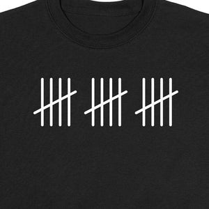 以下が含まれることがあります： 白いタリーマークのグラフィックが描かれた黒いTシャツ。タリーマークは15を表しています。