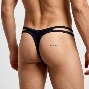 May include: Black thong underwear with a double strap design. The underwear is made of a soft, stretchy material. The brand name "PANDULCE" is printed on the right side.