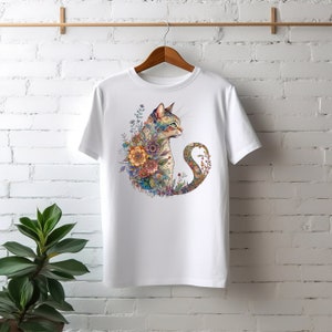 May include: White t-shirt featuring a colourful illustration of a cat surrounded by flowers. The cat is looking to the right and its tail is curled around its body.
