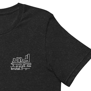 May include: A black short-sleeved t-shirt with a white graphic design of a building with the text "brutal." underneath.