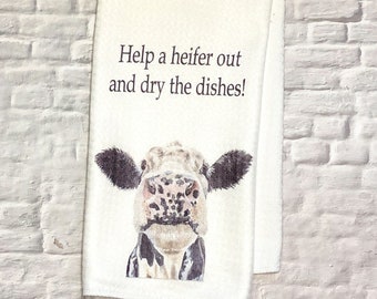May include: White kitchen towel with a black and white cow illustration and the text "Help a heifer out and dry the dishes!"