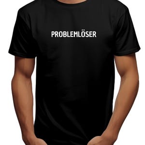 Könnte beinhalten: Schwarzes T-Shirt mit weißem Text "PROBLEMLÖSER".