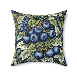 May include: A square throw pillow with a dark blue background featuring a stylized illustration of a blueberry bush with green leaves and blue berries.