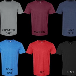 May include: A set of ten t-shirts in various colors, including military green, gunmetal grey, maroon, navy blue, white, rose, royal blue, red, black, and heather grey. The t-shirts are all crew neck and short-sleeved.