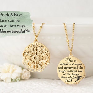 May include: Two gold-colored necklaces with pendant designs. One pendant is a filigree design, and the other is a round pendant with the text "She is clothed in strength and dignity, and she laughs without fear of the future. Proverbs 31:25". The text "PeekABoo necklace can be worn two ways... hidden or revealed" is also present.