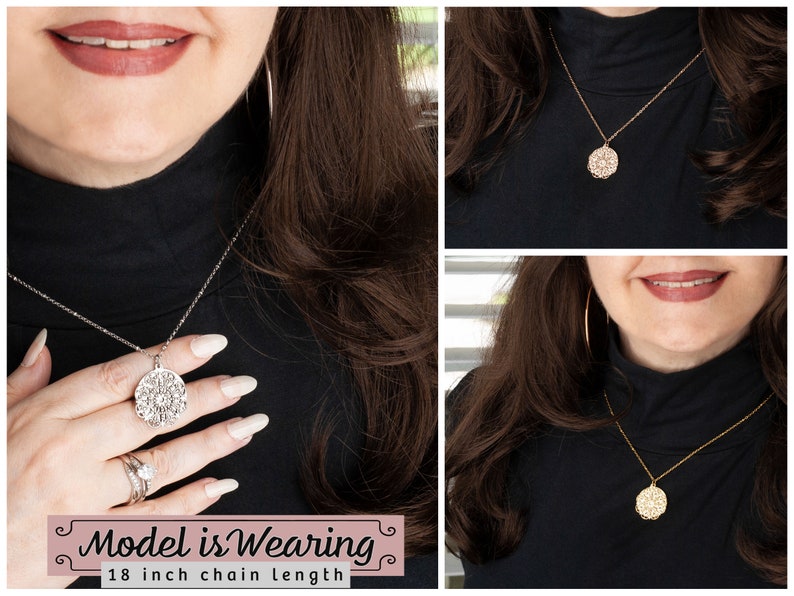 May include: A silver-toned necklace with an intricate, circular pendant is displayed. The pendant has a detailed, openwork design. The necklace is shown on a person wearing a black turtleneck. The text "Model is Wearing" and "18 inch chain length" is visible.