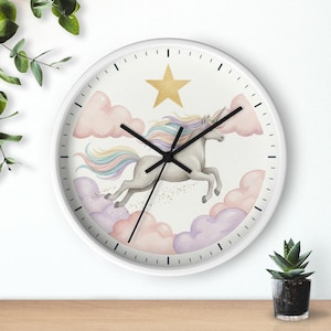 May include: A round wall clock with a white frame and a white face featuring a watercolor illustration of a grey unicorn with a rainbow mane and tail leaping through pink and purple clouds under a single gold star, with black clock hands.