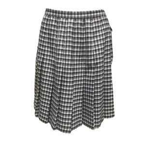 May include: A knee-length skirt with a classic black and white checkered pattern. The skirt features a pleated design, creating a full silhouette. The fabric appears to be a woven material, suitable for cooler weather.